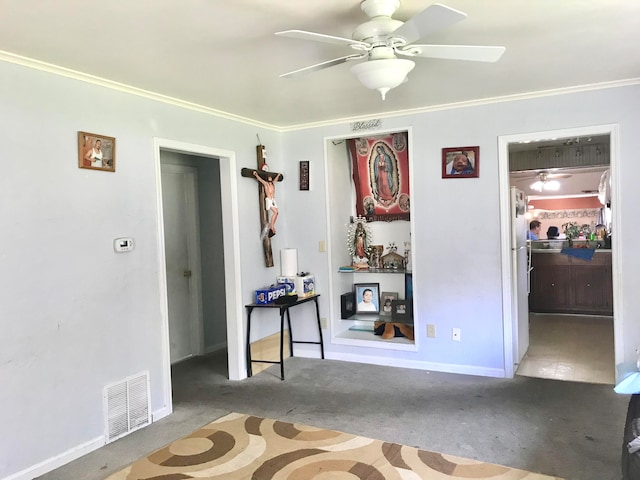 spare room with ceiling fan, ornamental molding, and light carpet