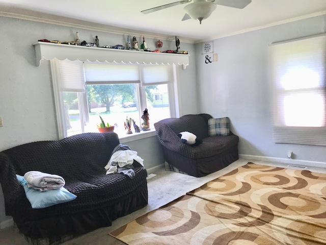 sitting room featuring ceiling fan, a healthy amount of sunlight, and ornamental molding