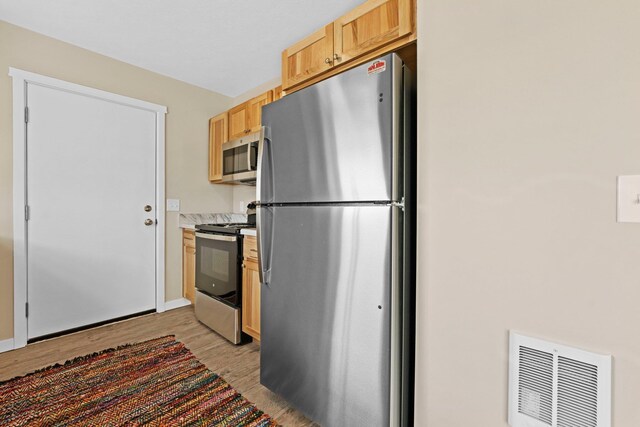 2835 Walton Rd, Kingsley, MI 49649 - kitchen with stainless steel appliances, light wood-type flooring, and light countertops
