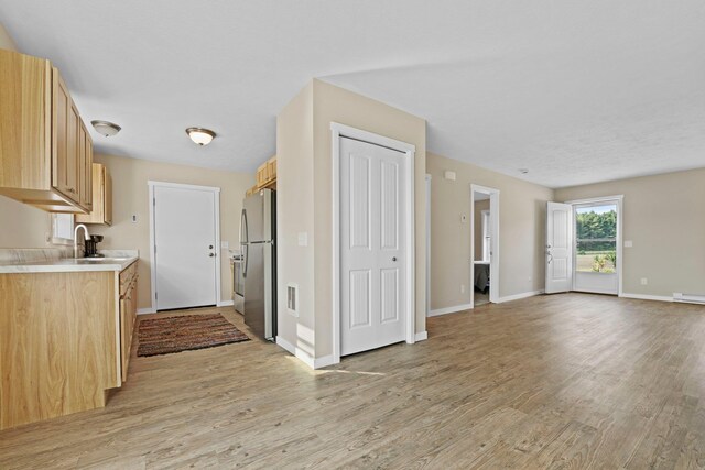 2835 Walton Rd, Kingsley, MI 49649 - kitchen featuring freestanding refrigerator, light wood-style floors, light countertops, light brown cabinets, and baseboards
