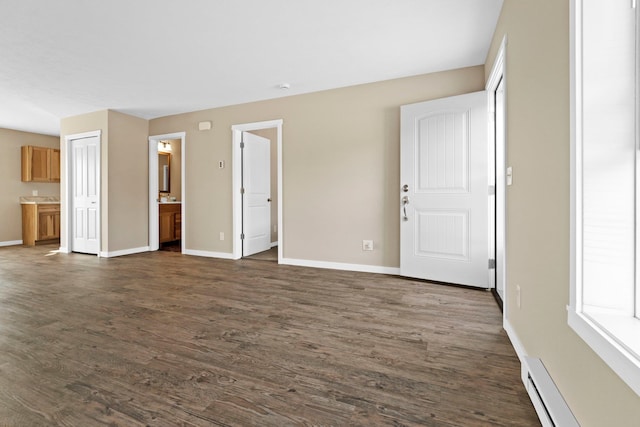 unfurnished living room featuring baseboard heating and dark hardwood / wood-style floors