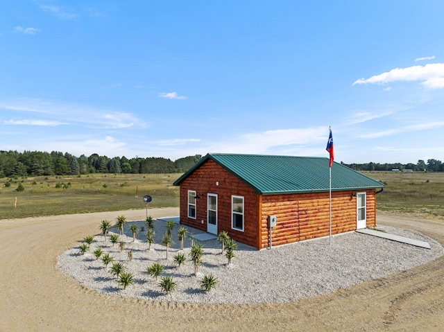 2835 Walton Rd, Kingsley, MI 49649 - view of side of home with faux log siding, metal roof, and a rural view
