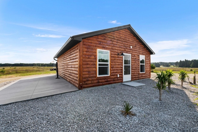 back of property featuring a rural view