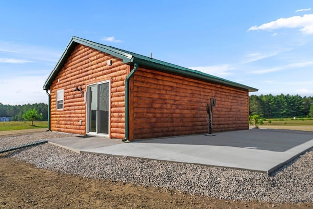 2835 Walton Rd, Kingsley, MI 49649 - view of side of property featuring faux log siding and a patio