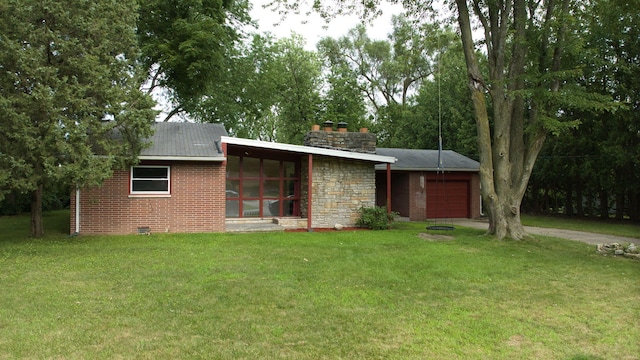 view of front of home with a front yard, a garage, and a sunroom