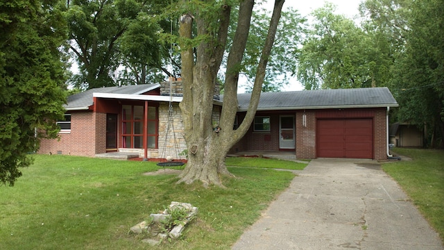 view of front of home featuring an attached garage, brick siding, driveway, stone siding, and a front yard