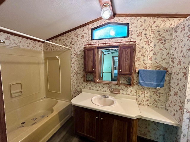 bathroom featuring  shower combination, a textured ceiling, lofted ceiling, vanity, and ornamental molding