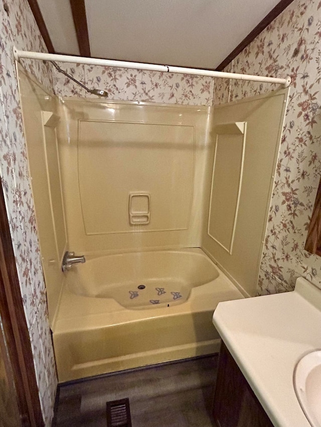 bathroom with hardwood / wood-style flooring, vanity, crown molding, and bathtub / shower combination