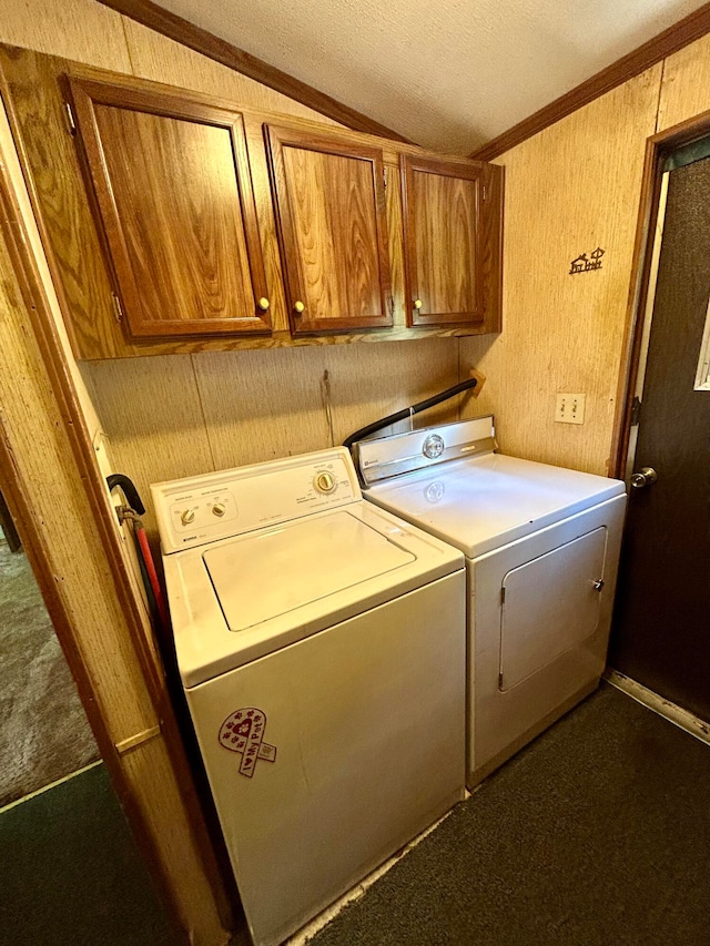 laundry room featuring washer and clothes dryer, cabinets, a textured ceiling, and ornamental molding