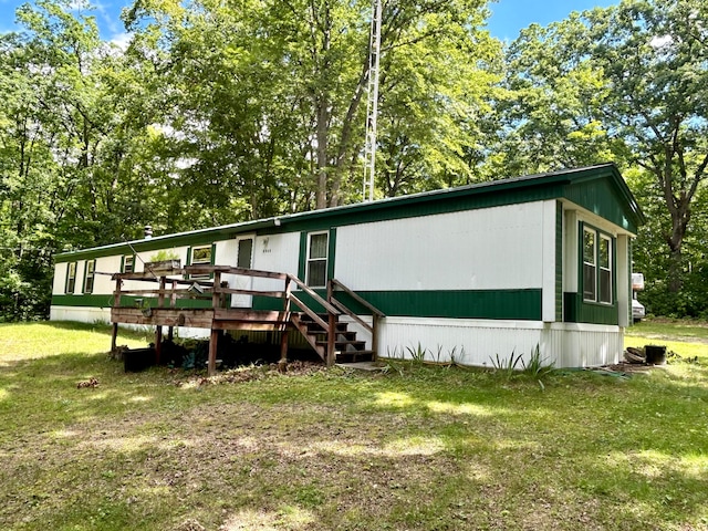 view of front of home with a deck and a front lawn