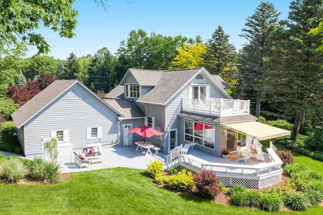 5925 Jagger Rd, Ludington, MI 49431 - rear view of property featuring a balcony, a yard, a wooden deck, and roof with shingles