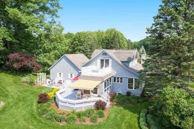 5925 Jagger Rd, Ludington, MI 49431 - back of house with a balcony, a lawn, a deck, and a shingled roof