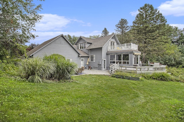5925 Jagger Rd, Ludington, MI 49431 - rear view of property featuring a balcony, a lawn, and a patio area
