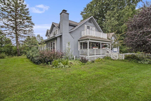 5925 Jagger Rd, Ludington, MI 49431 - rear view of house with a balcony, covered porch, and a chimney