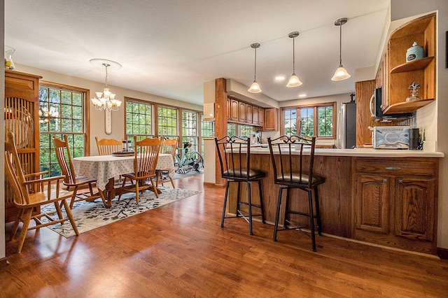 5925 Jagger Rd, Ludington, MI 49431 - kitchen with open shelves, brown cabinetry, freestanding refrigerator, dark wood finished floors, and healthy amount of natural light