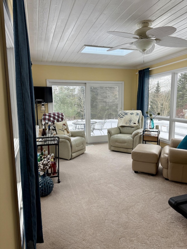 5925 Jagger Rd, Ludington, MI 49431 - carpeted living area featuring ceiling fan, wooden ceiling, a skylight, and crown molding