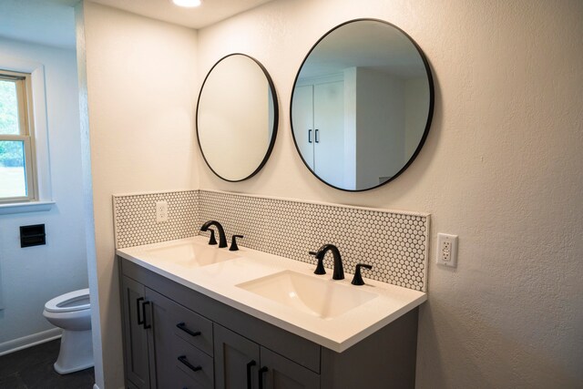 bathroom featuring backsplash, vanity, and toilet