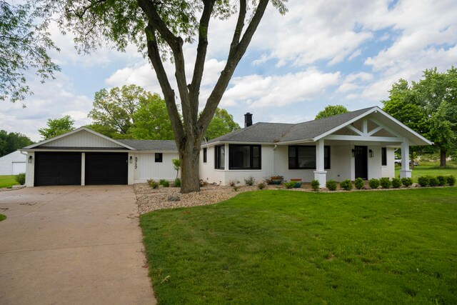 view of front of property with a front yard, a porch, and a garage