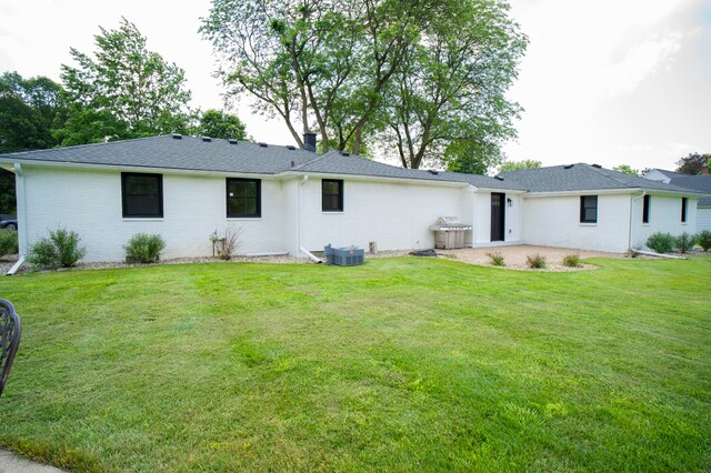 rear view of property featuring a yard and central AC