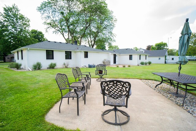 rear view of house featuring a yard and a patio