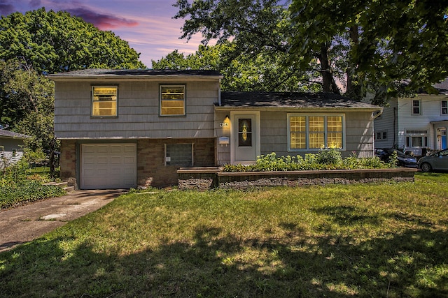 tri-level home with a garage and a yard