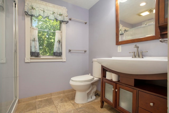 bathroom featuring a textured ceiling, vanity, toilet, and a shower with shower door