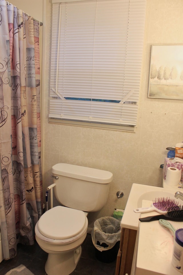 bathroom featuring vanity, curtained shower, toilet, and tile walls