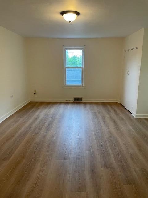 empty room with hardwood / wood-style flooring