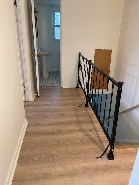 stairway with wood-type flooring and sink