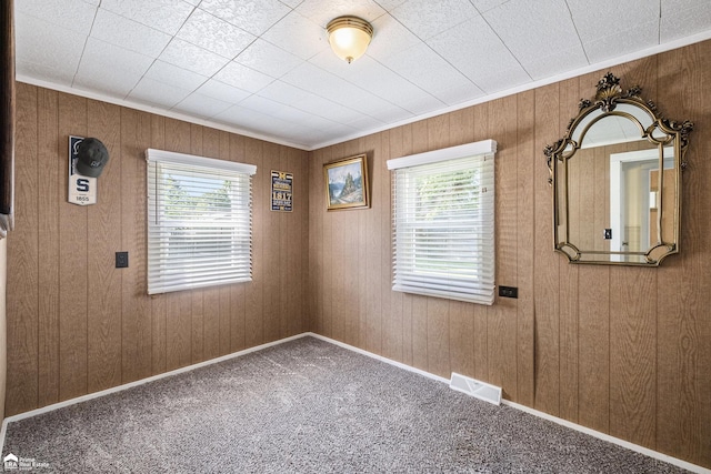 1029 Boatfield Ave, Flint, MI 48507 - spare room featuring healthy amount of natural light, carpet flooring, wooden walls, and ornamental molding