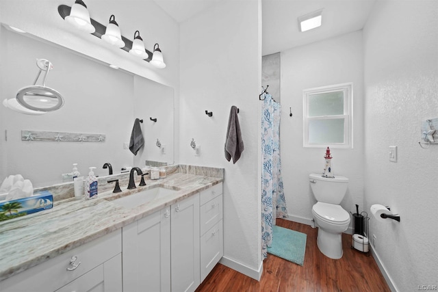 bathroom featuring hardwood / wood-style floors, vanity, toilet, and curtained shower