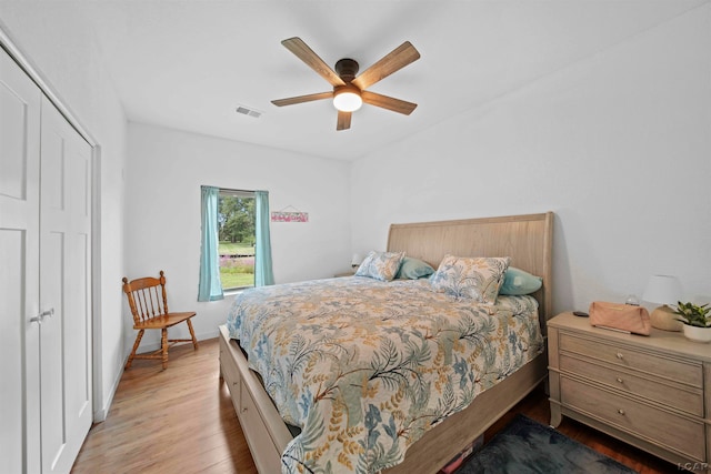 bedroom with a closet, light hardwood / wood-style floors, and ceiling fan