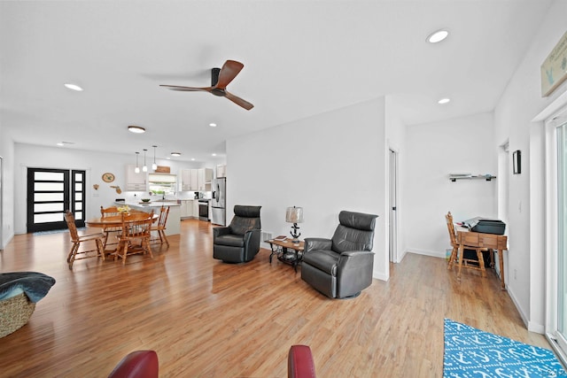 living room with light wood-type flooring and ceiling fan