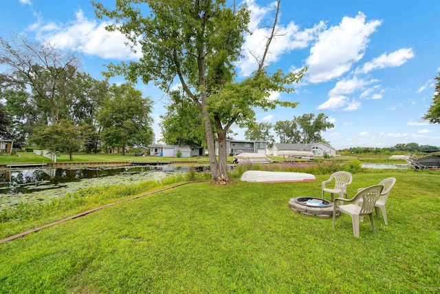 view of yard featuring a water view and a fire pit