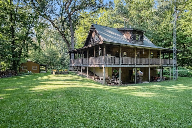 rear view of house featuring an outdoor structure and a lawn