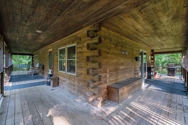 wooden deck with a grill and covered porch