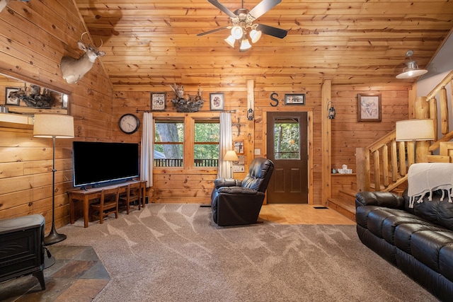 carpeted living room featuring a wood stove, wooden walls, and wood ceiling