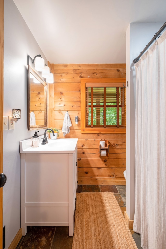 bathroom with a shower with shower curtain, vanity, and wooden walls