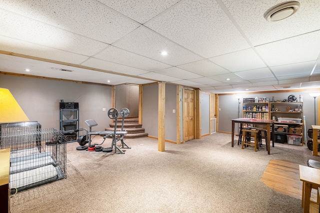 exercise room with a paneled ceiling and carpet floors