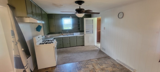 3150 Swaffer Rd, Millington, MI 48746 - kitchen with white gas range, under cabinet range hood, green cabinetry, a sink, and wood walls