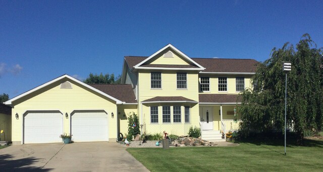 view of front of property with a garage and a front lawn