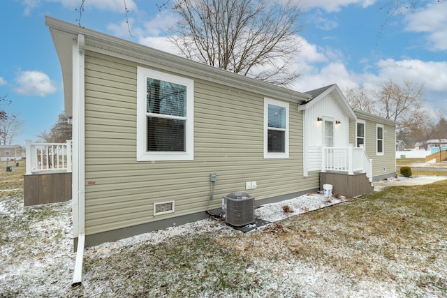 view of snowy exterior with cooling unit