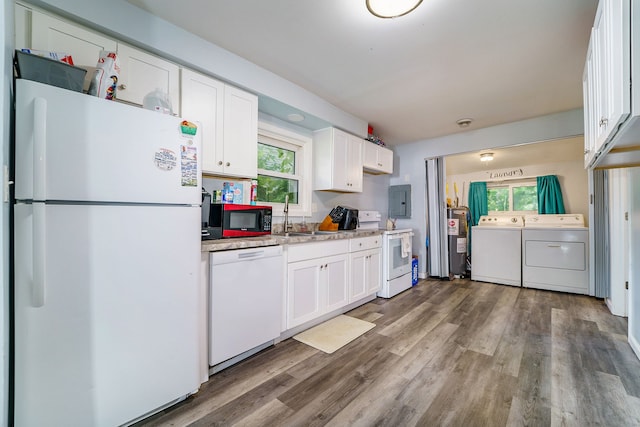 kitchen featuring white cabinets, washer and dryer, a healthy amount of sunlight, and white appliances