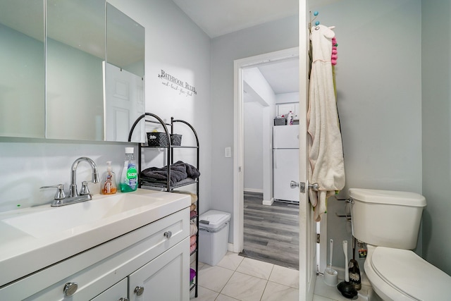 bathroom with wood-type flooring, vanity, and toilet