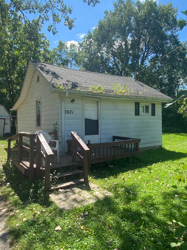 rear view of property with a lawn and a deck