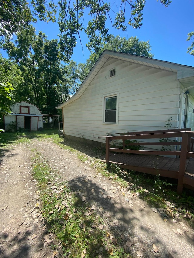 view of property exterior with a storage shed and a wooden deck