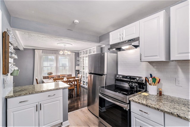 kitchen with white cabinets, light stone countertops, light wood-type flooring, appliances with stainless steel finishes, and tasteful backsplash