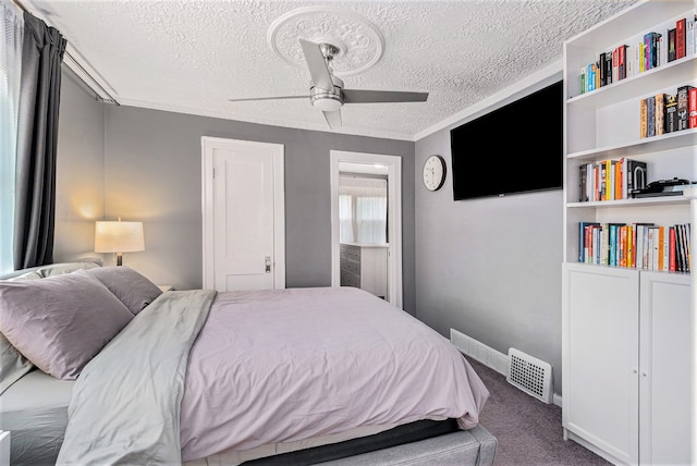 bedroom featuring ceiling fan, carpet floors, and a textured ceiling