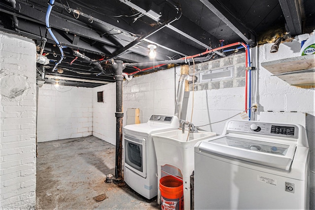 clothes washing area featuring independent washer and dryer and sink