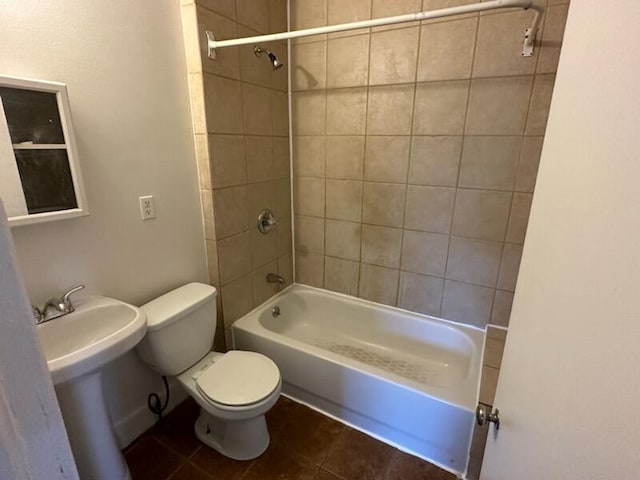 full bathroom with tile patterned flooring, tiled shower / bath combo, toilet, and sink